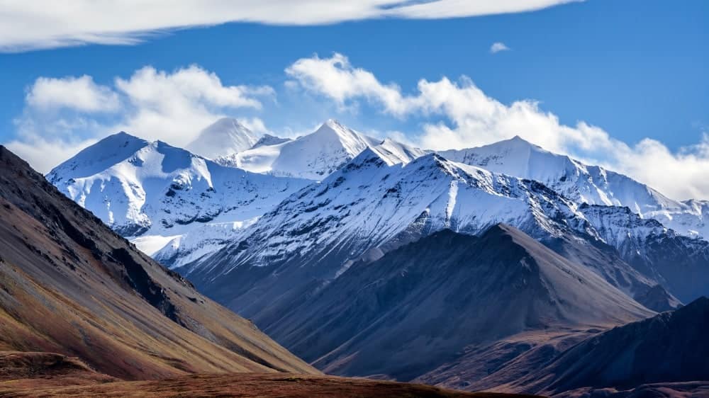 The early-Autumn snow-line is clearly illustrated across a portion of the Alaska range in Denali National Park, Alaska.