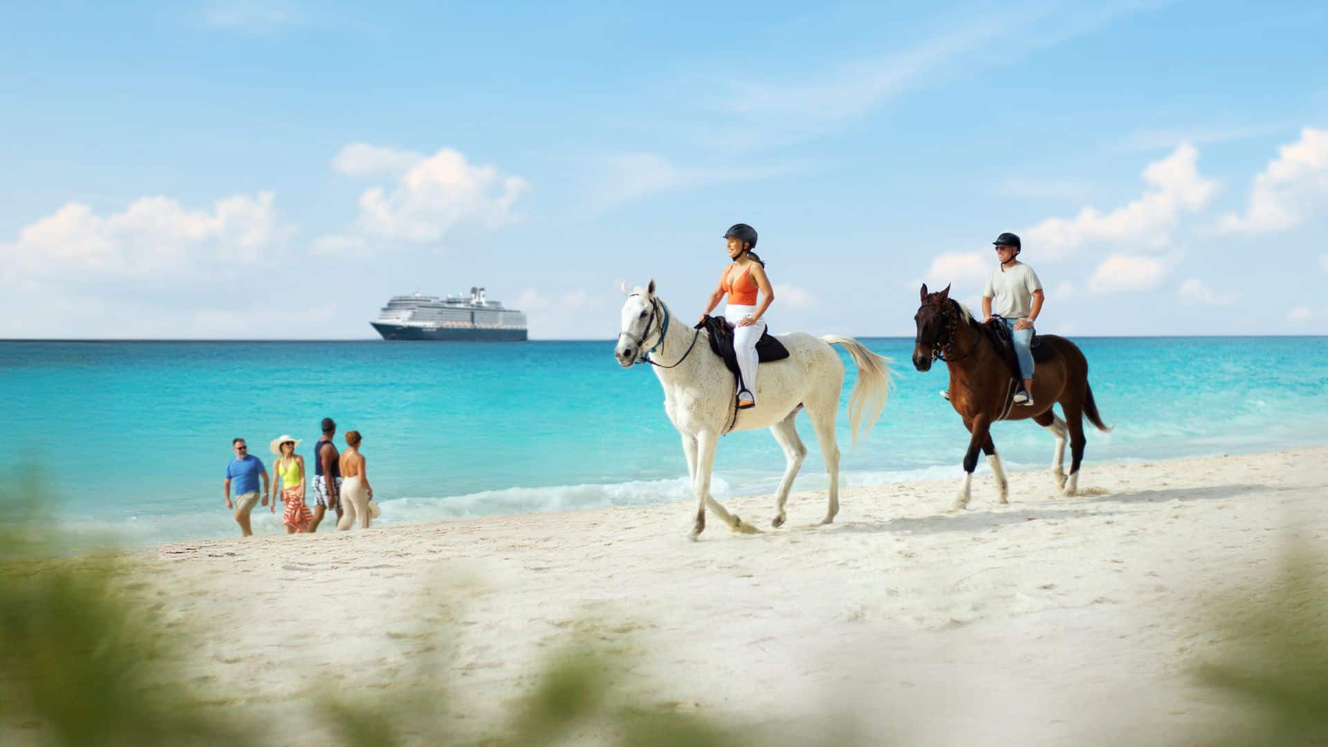 People ride horses along a sandy beach near the ocean with a cruise ship offshore.