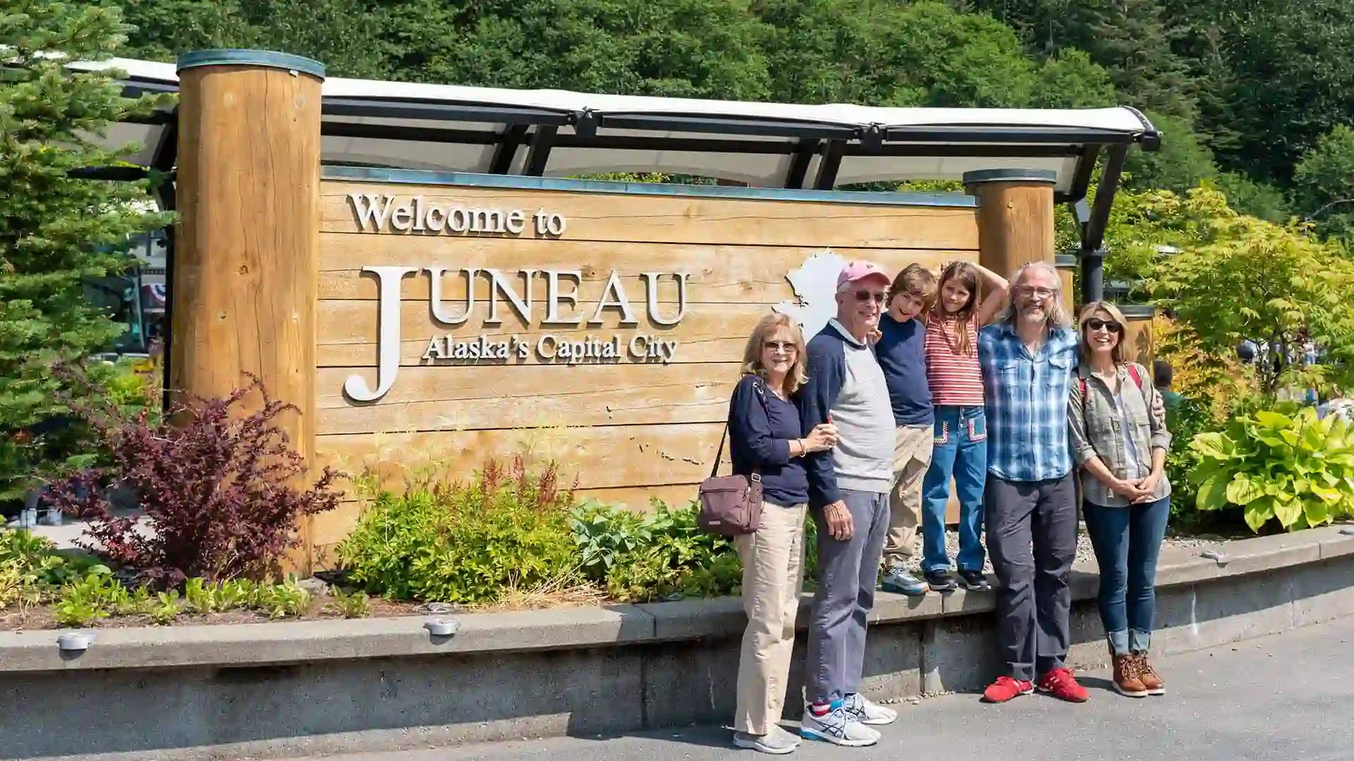 Travel expert Samantha Brown with family in front of Juneau Alaska sign.