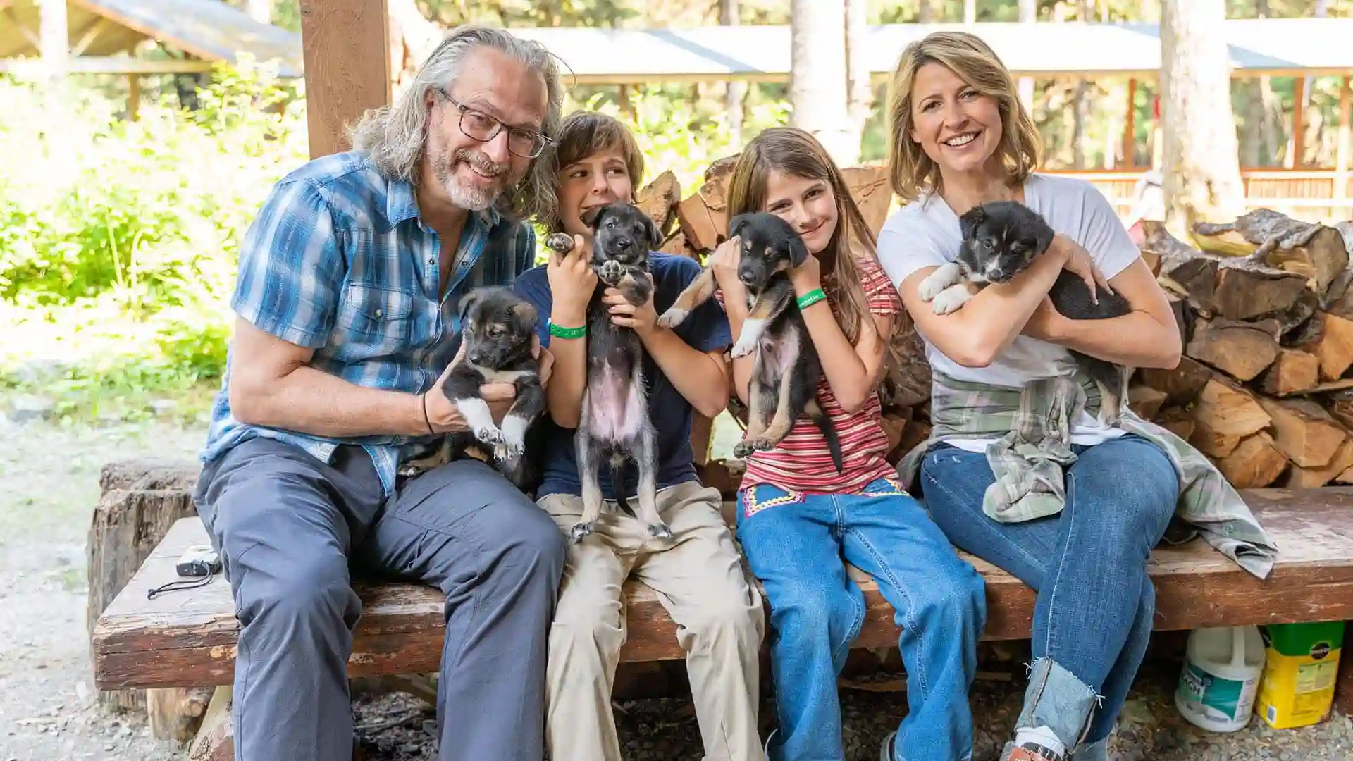 Travel expert Samantha Brown with family holding puppies in Alaska.