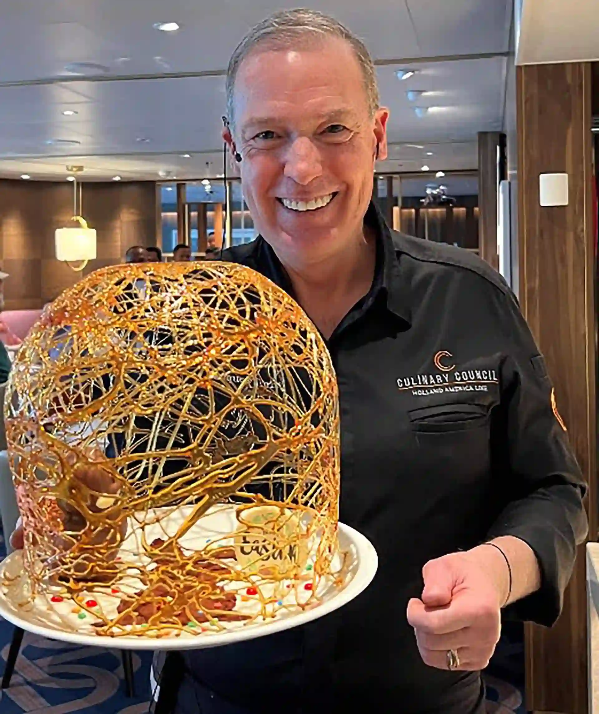 Person in chef uniform holding dessert.