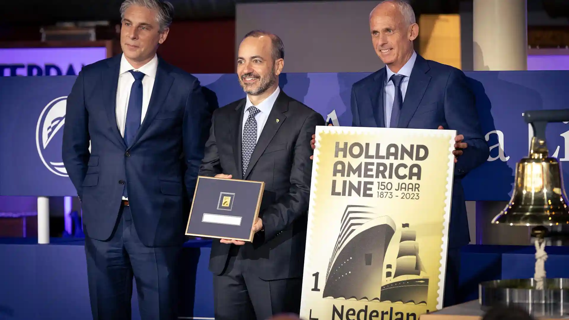 People smiling and holding framed certificate at ceremony celebrating Holland America Line's 150th anniversary.