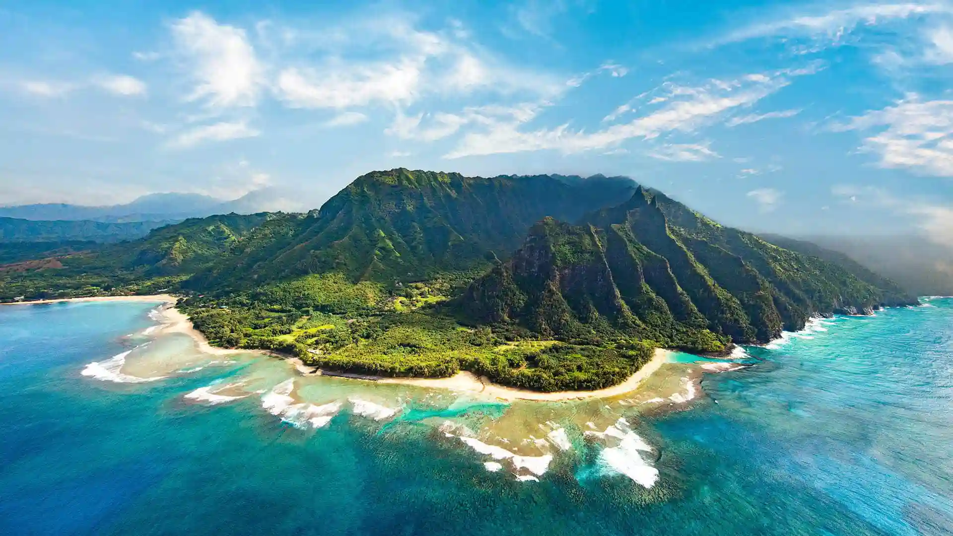 Aerial view of Hawaiian island surrounded by bright blue water.