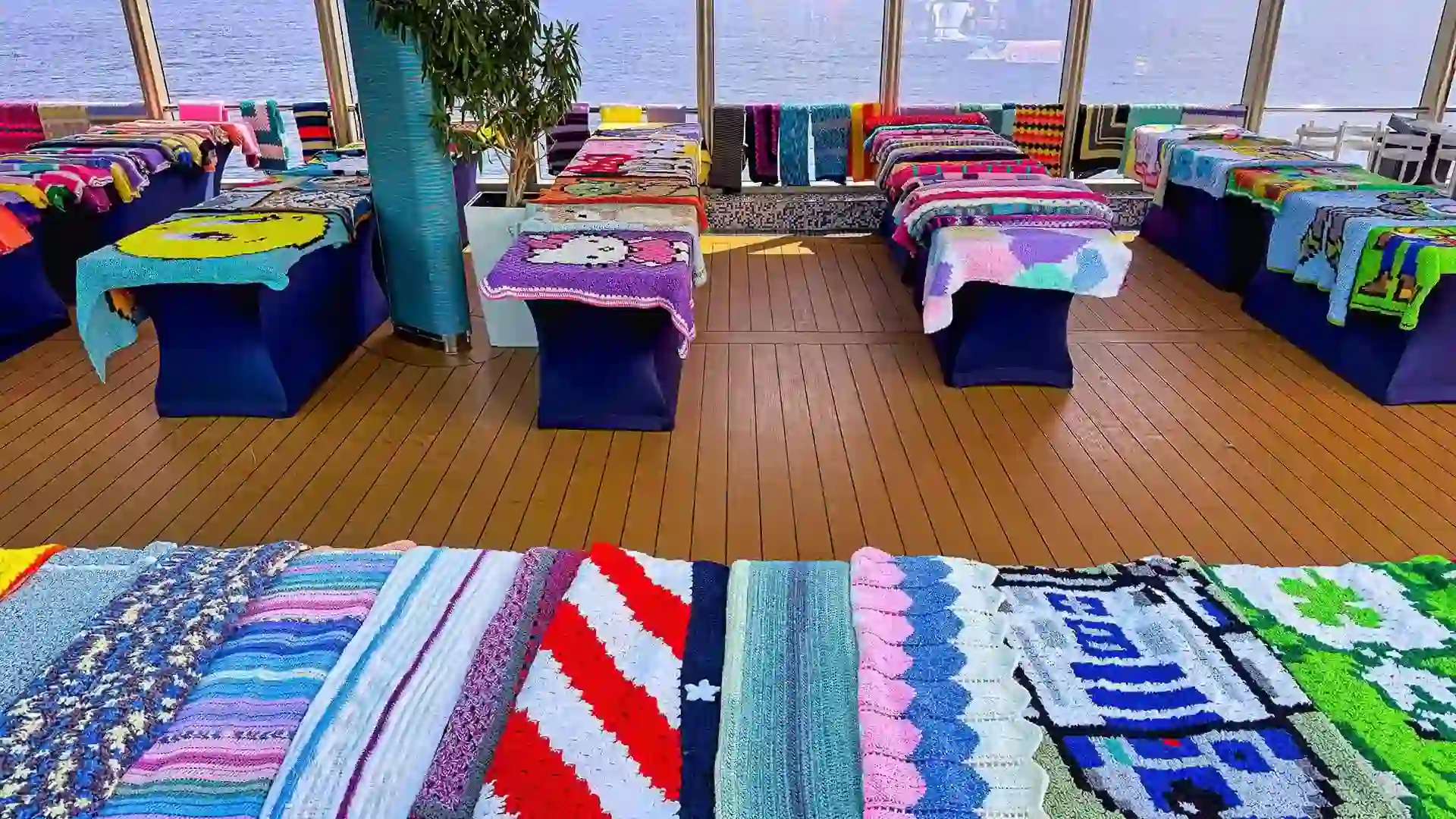 View of multicolored blankets displayed on Holland America Line cruise deck.