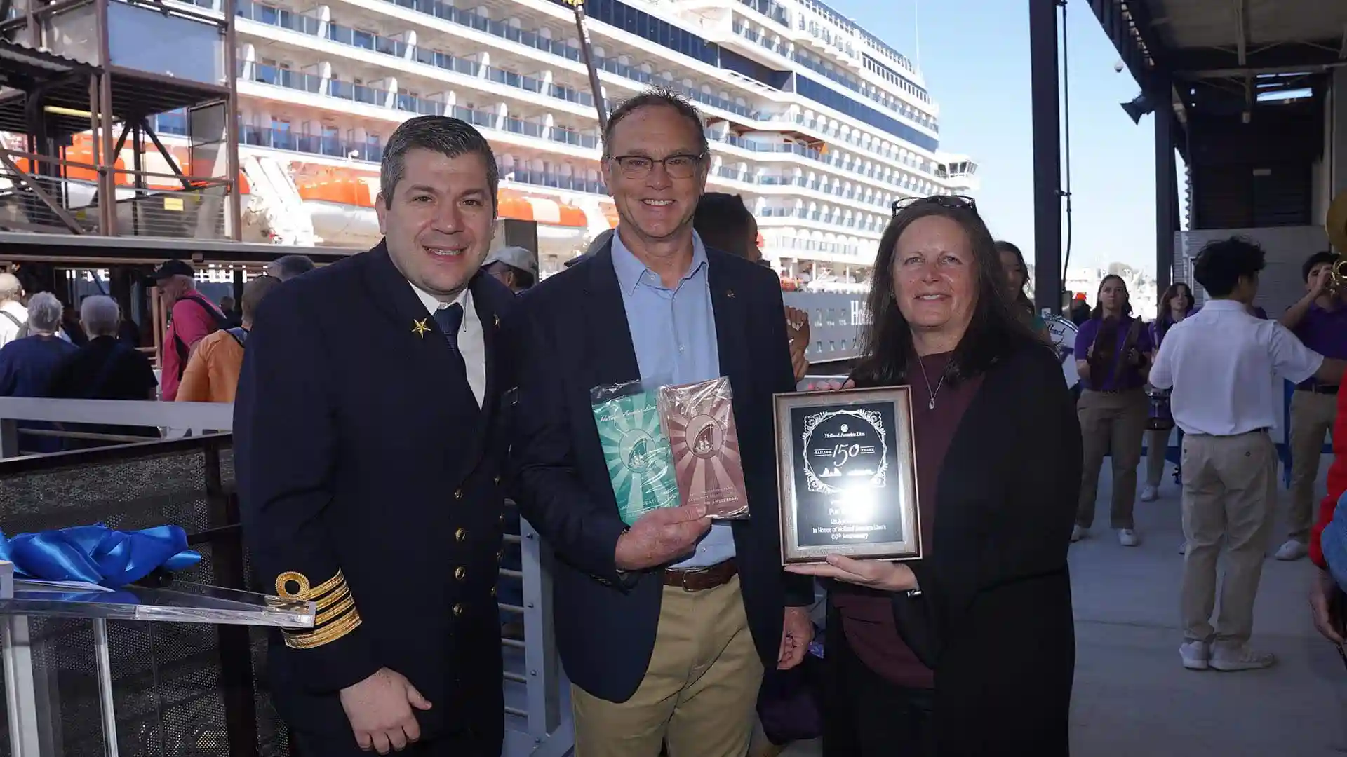 View of people holding Holland America Line 150th Anniversary plaque.