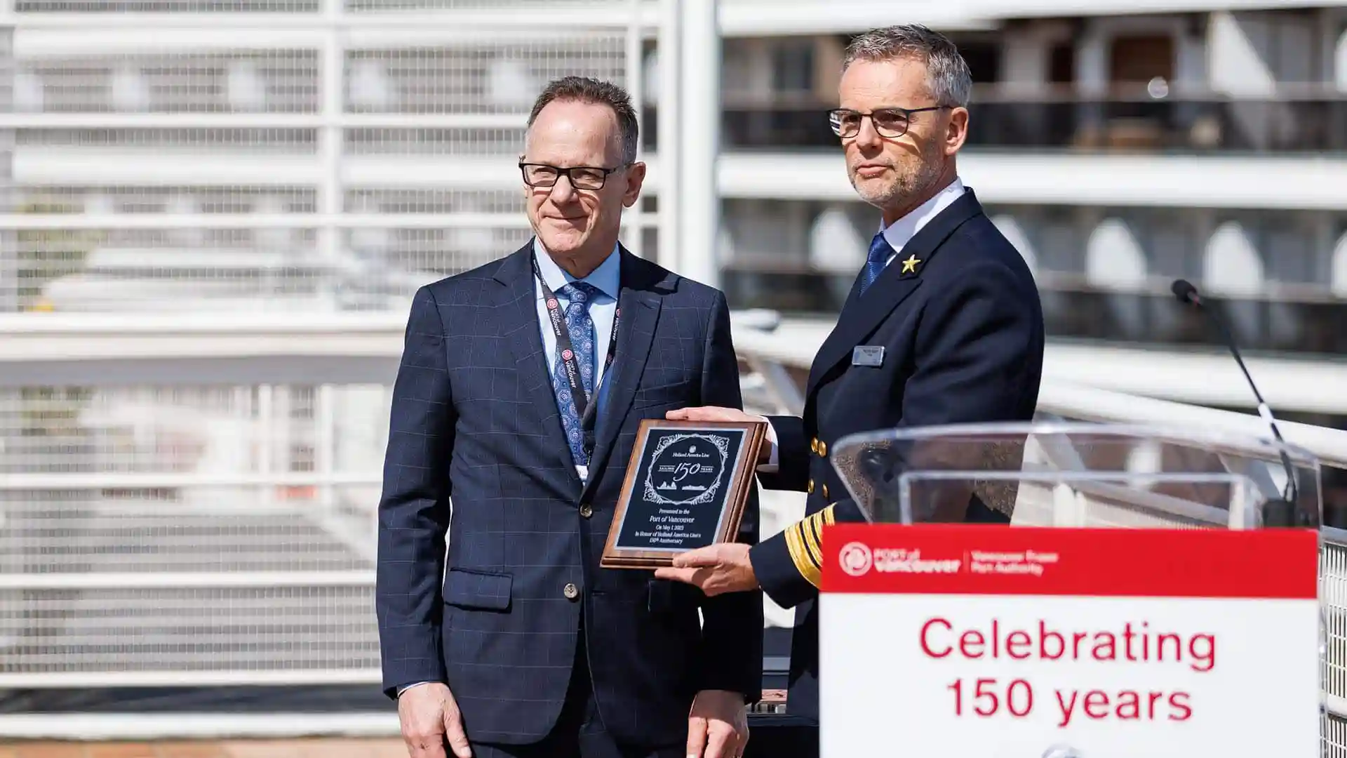 View of people holding Holland America Line 150th Anniversary plaque.