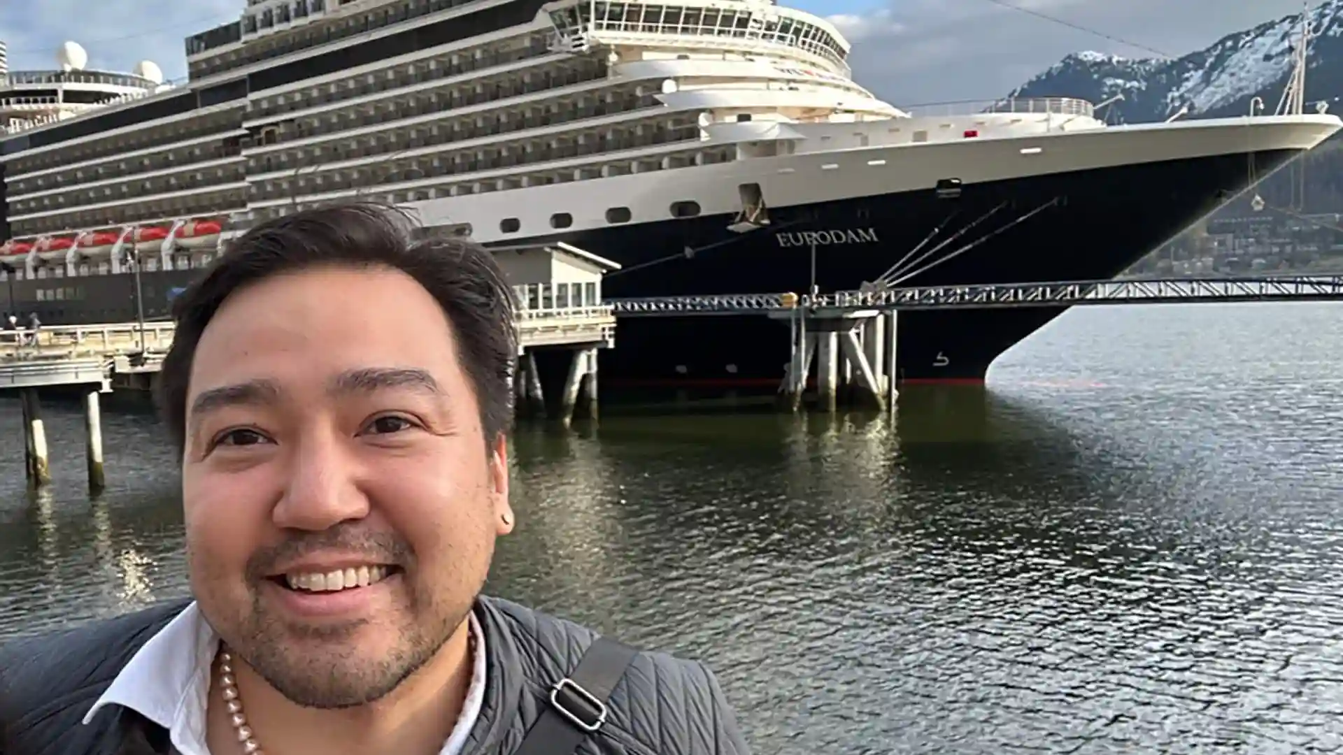 View of Rico Worl, Alaska Native artist, at Port of Juneau, with Holland America Line cruise ship in background.