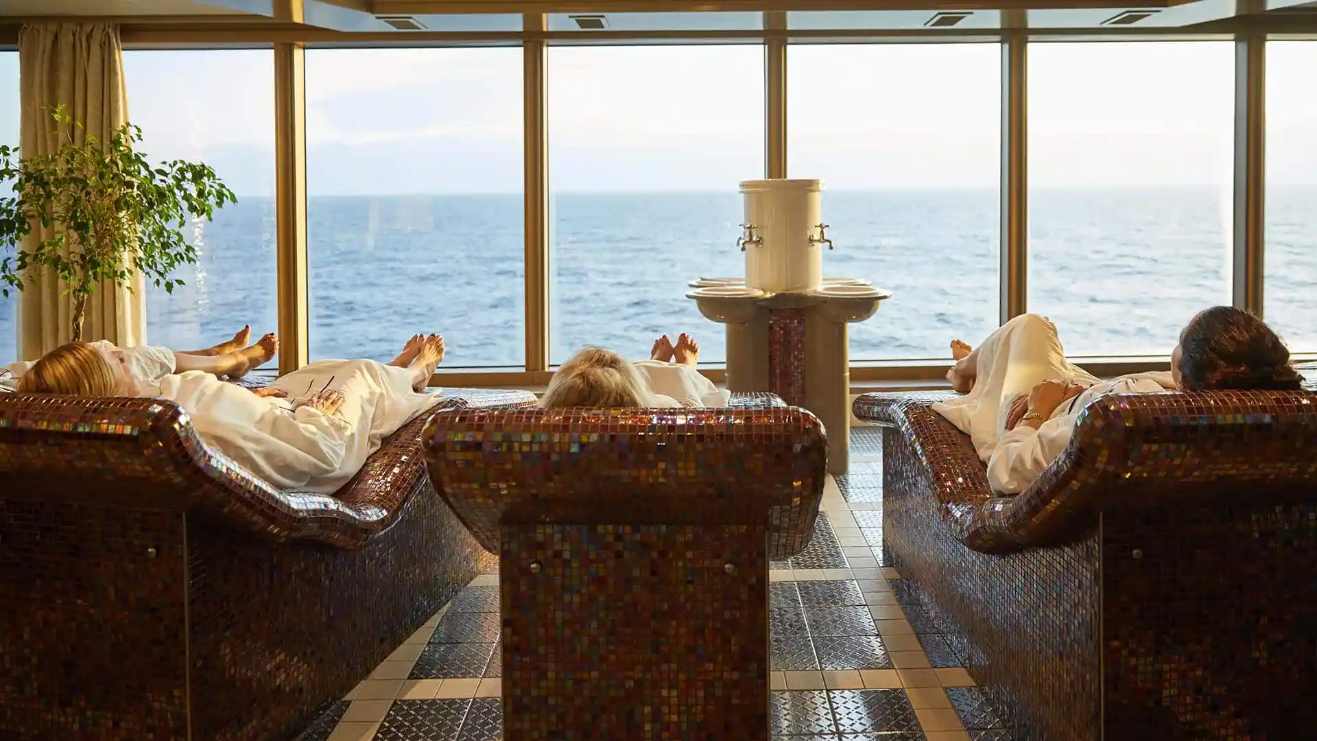 People lounging in spa with ocean views.