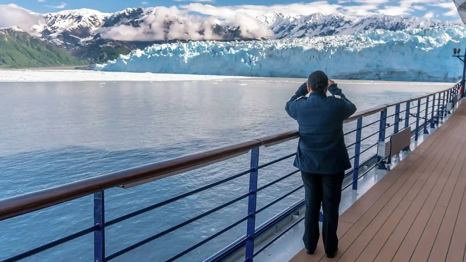 Person viewing Alaska glaciers from cruise ship deck.
