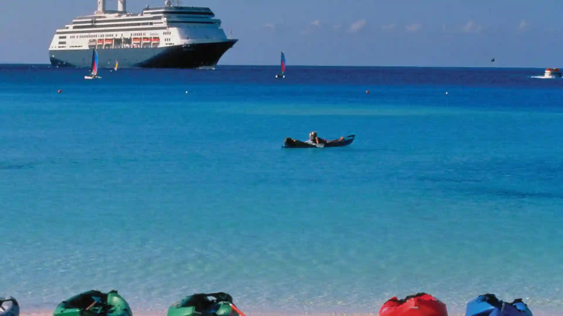 View of cruise ship, boats and kayak from shores of Half Moon Cay in Bahamas.