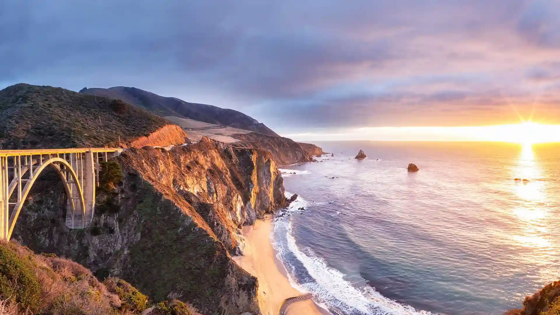 View of Pacific Coast Highway at sunset near ocean waters.