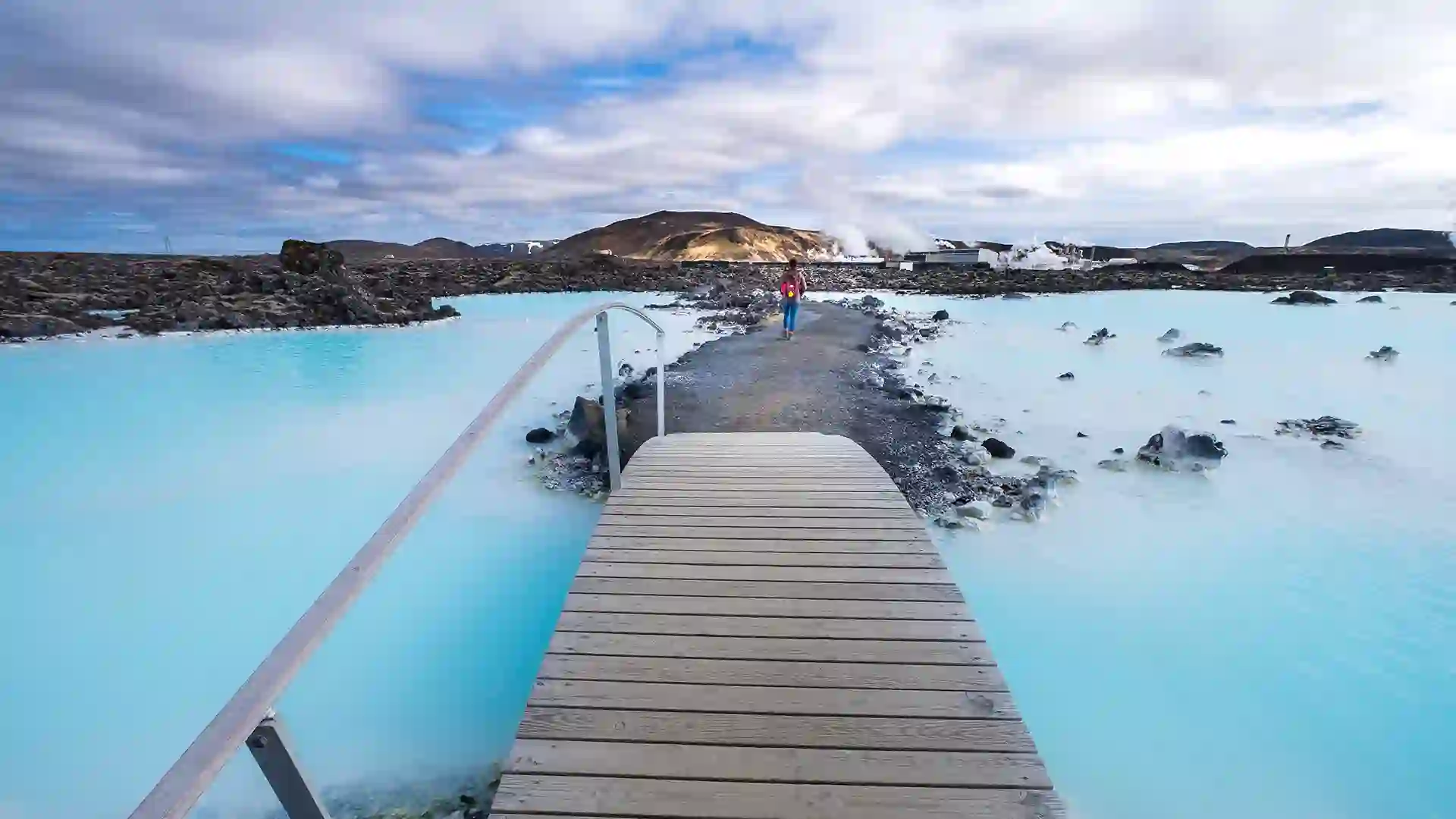 View of pathway over Iceland waters with person looking out in the distance.