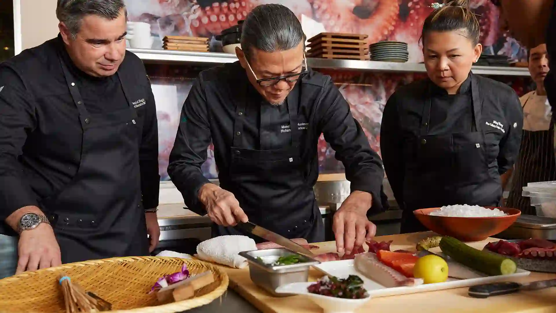 People in black uniforms cooking a meal.