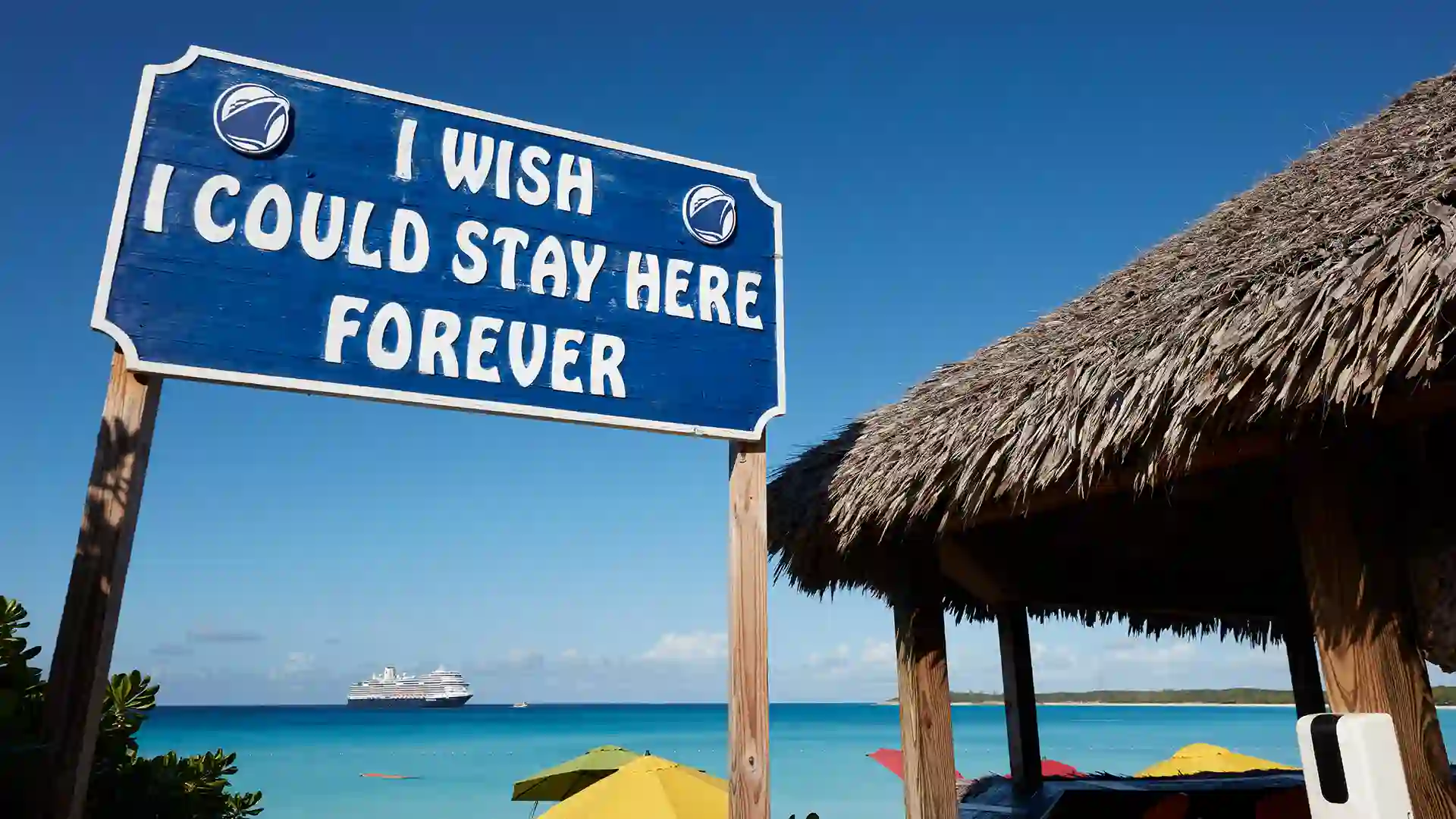 Half Moon Cay, Bahamas Sign that says "I wish I could stay here forever" with bright blue waters and cruise ship in background.