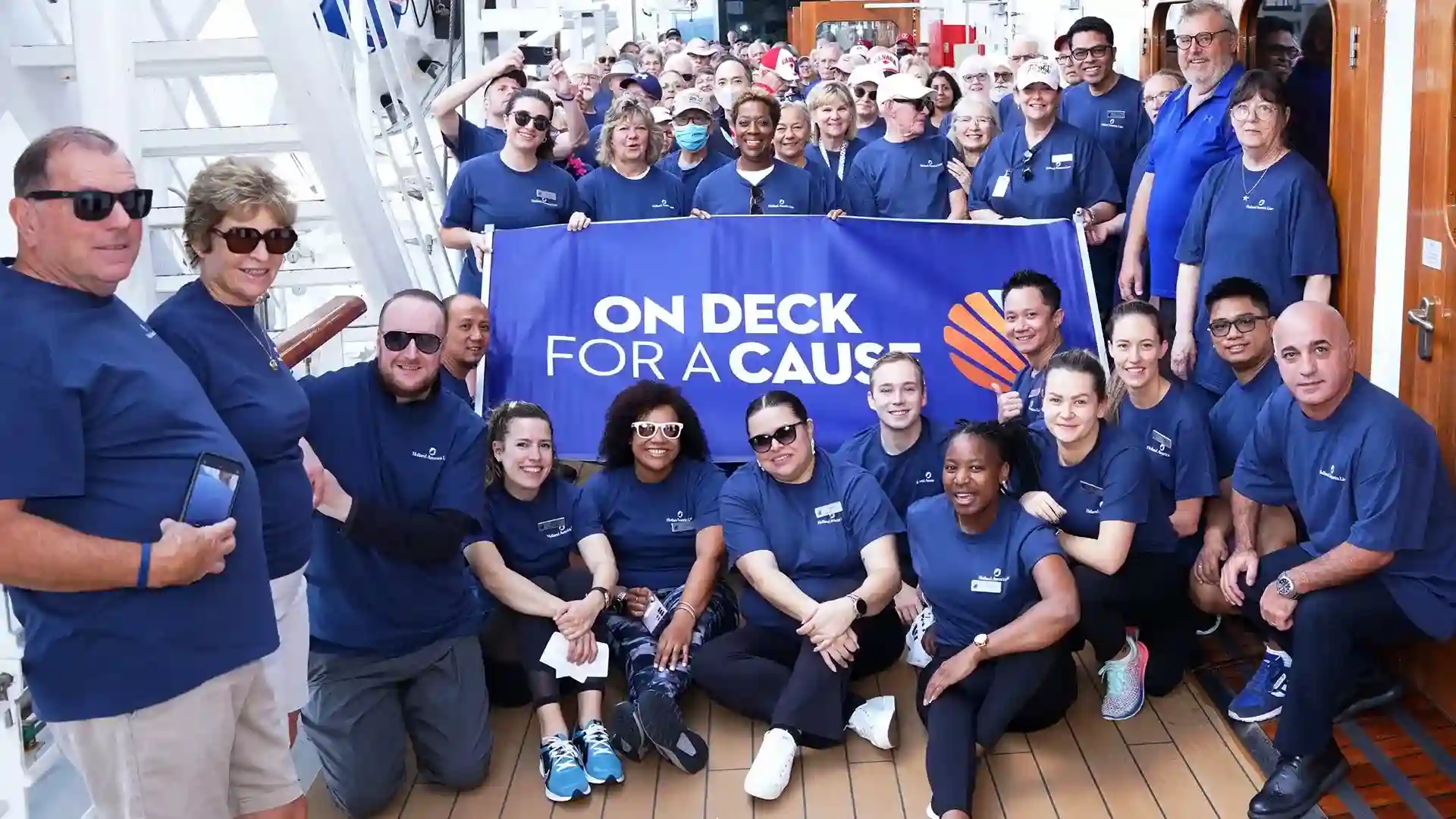 On Deck for a Cause Photo of people around blue sign that says On Deck for a Cause.