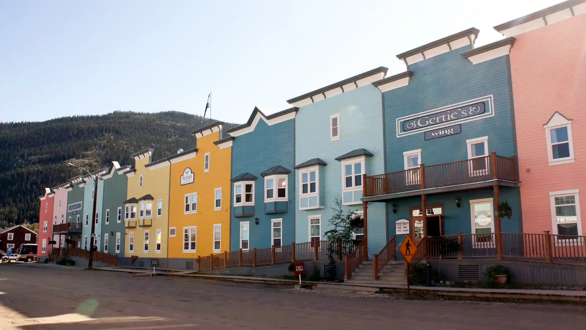 View of yellow, blue and pink-colored buildings on a street in small town.