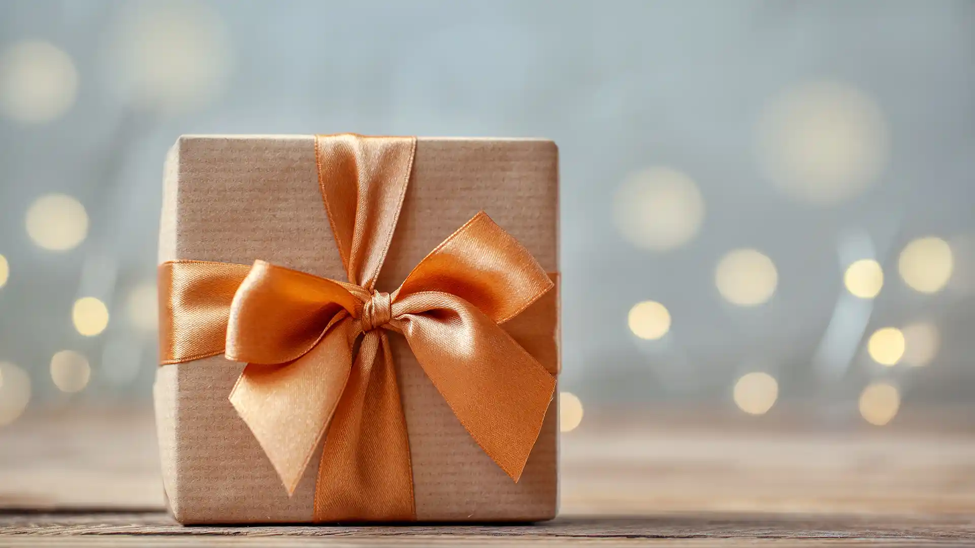 View of gift box wrapped in orange bow.