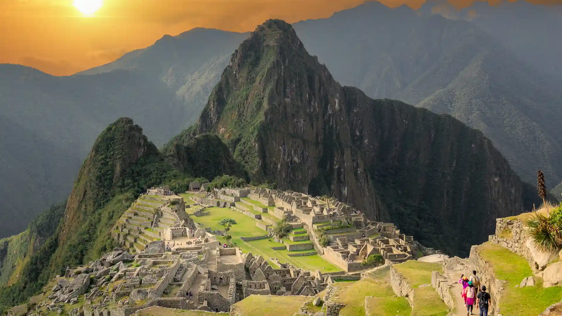 View of Machu Picchu, an ancient citadel in South America, surrounded by mountains and green landscape.