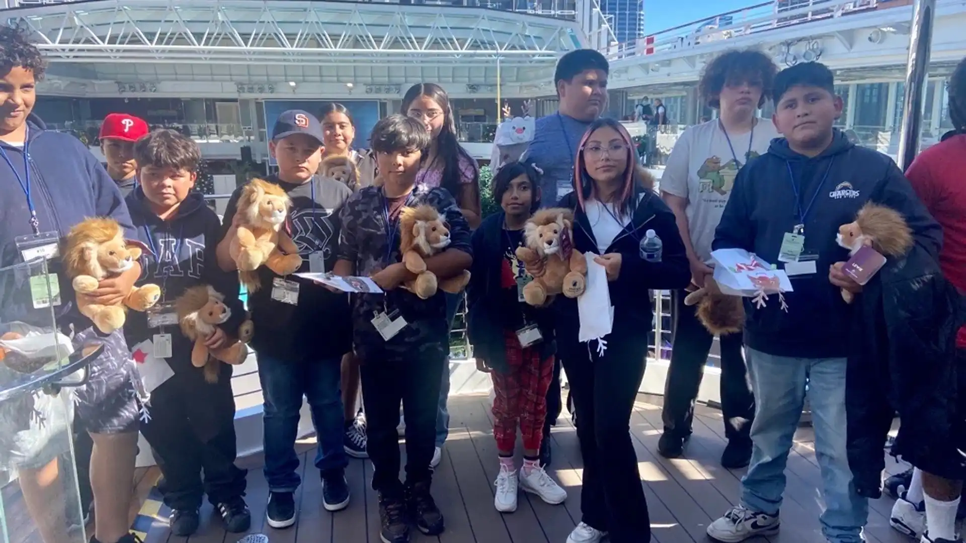 San Diego students gather on Holland America Line cruise ship, holding Lewie the Lion stuffed animals.