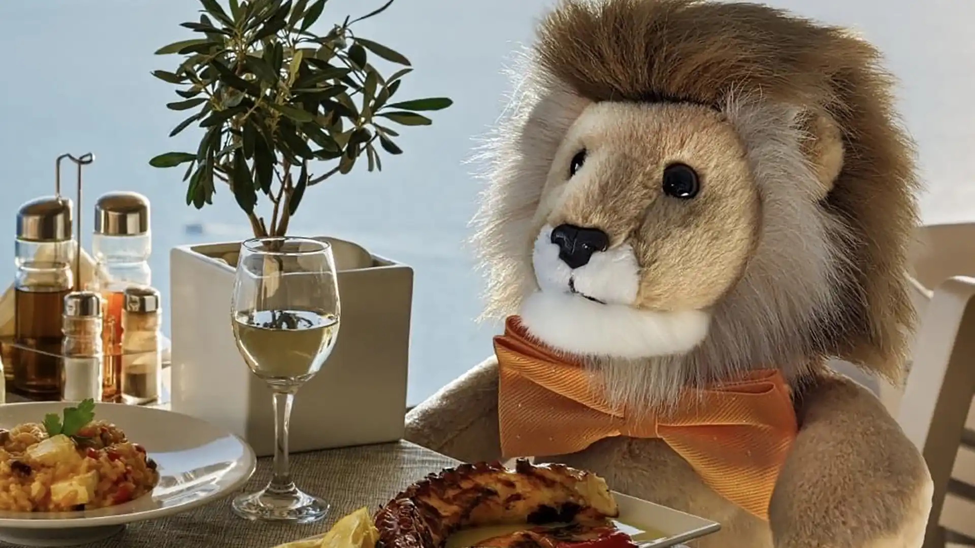 Holland America Line's lion mascot sitting at a dining room table next to large window with fish and rice on a platter.