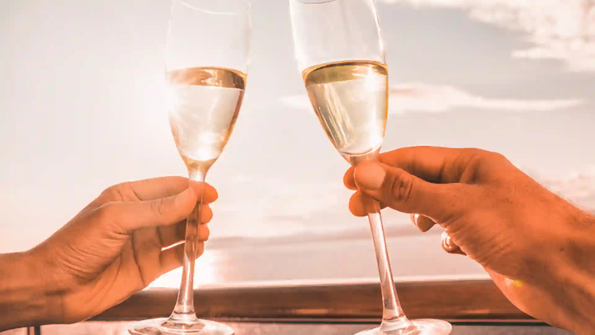 View of champagne glasses with ocean views in background.