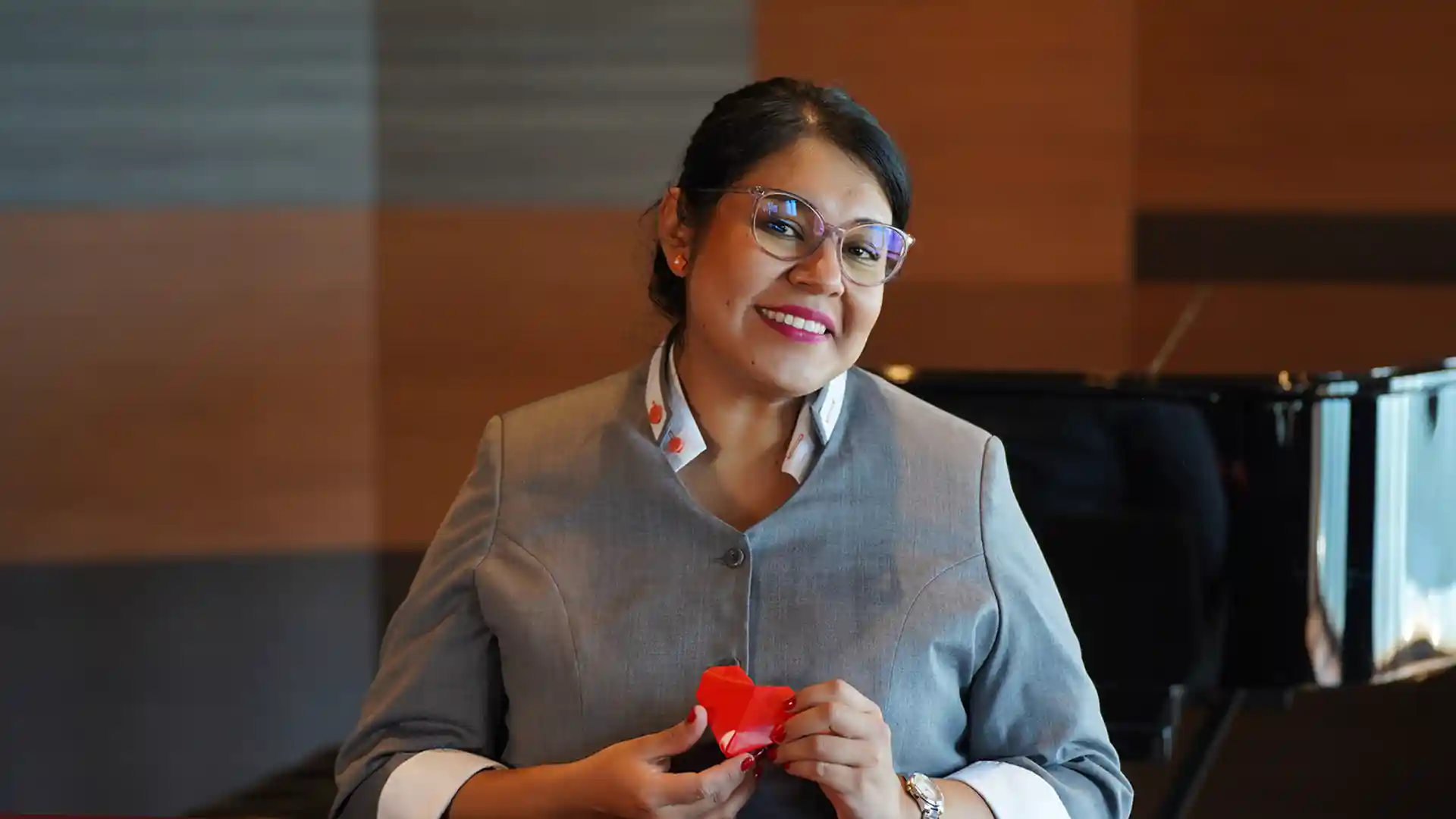 View of Holland America Line crew member holding a red origami heart for Valentine's Day.