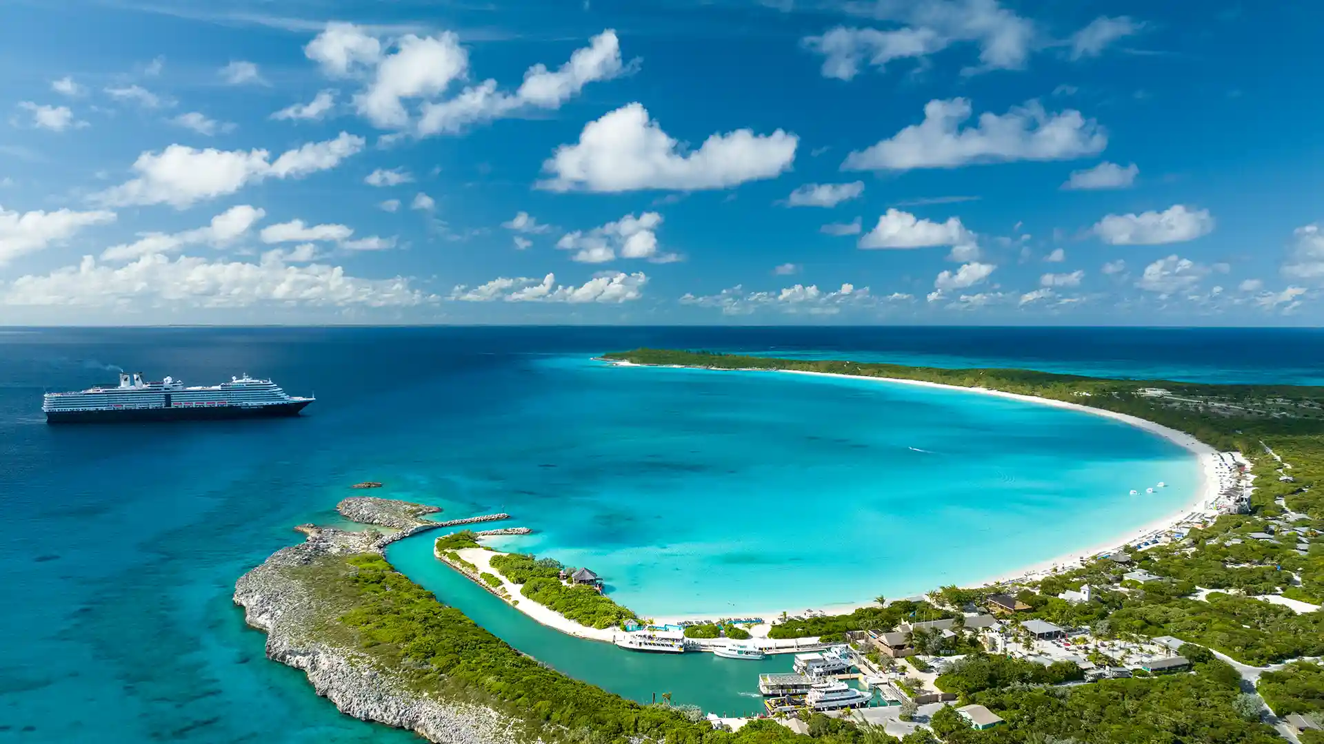 View of Holland America Line's private island, Half Moon Cay, in Bahamas with cruise ship in background.