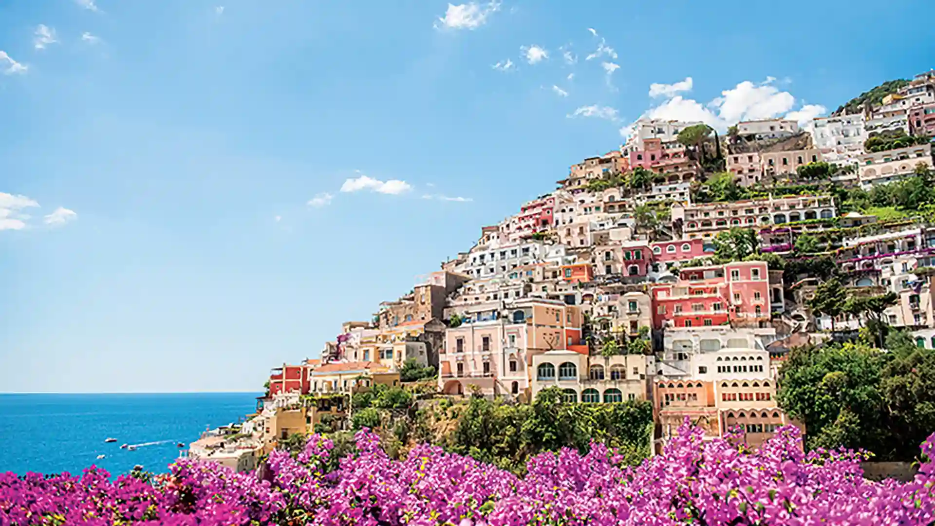 View of hillside buildings and flowers along Amalfi Coast in Italy.