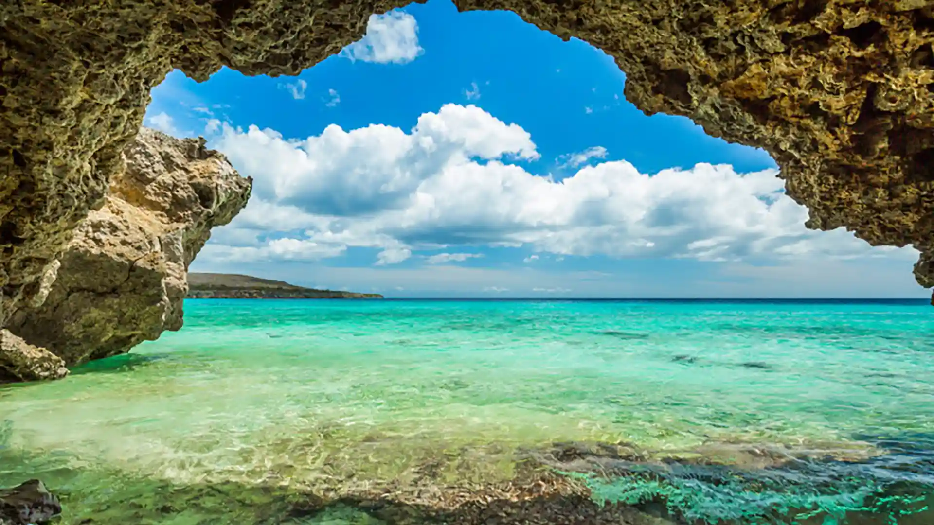 View of bright blue ocean waters from a cave structure in Curacao.