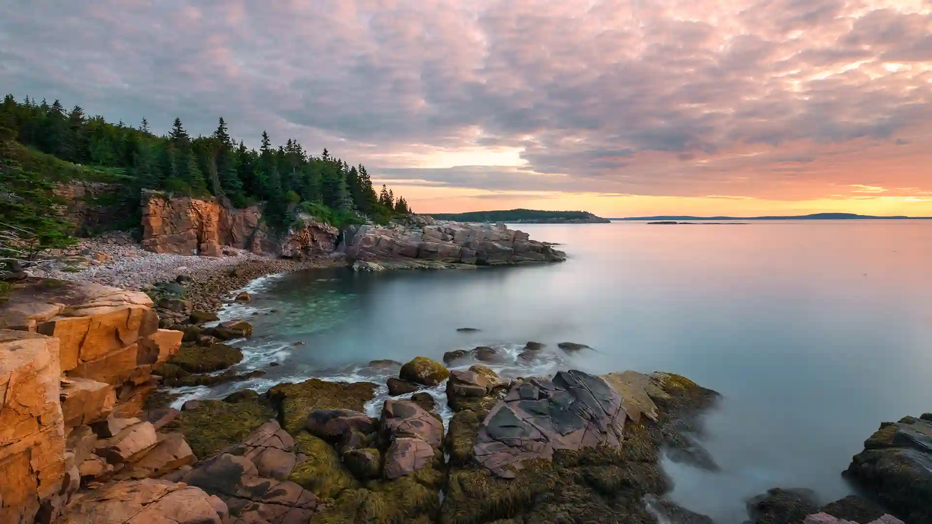 View of Acadia National Park, with its dramatic rocky cliffs, along the shore in Maine.