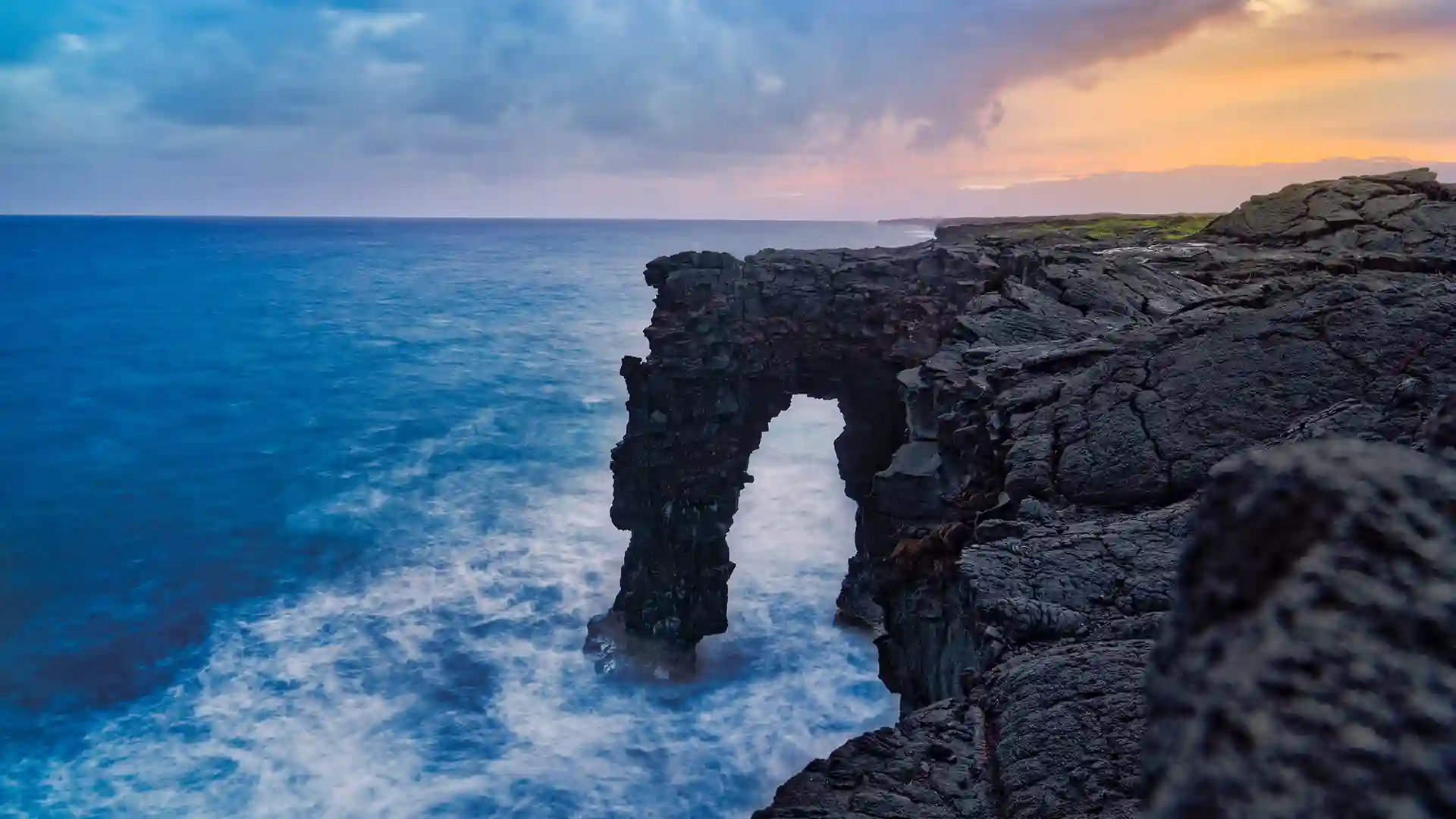 View of Holei Sea Arch in Hawaii Volcanoes National Park along shoreline.