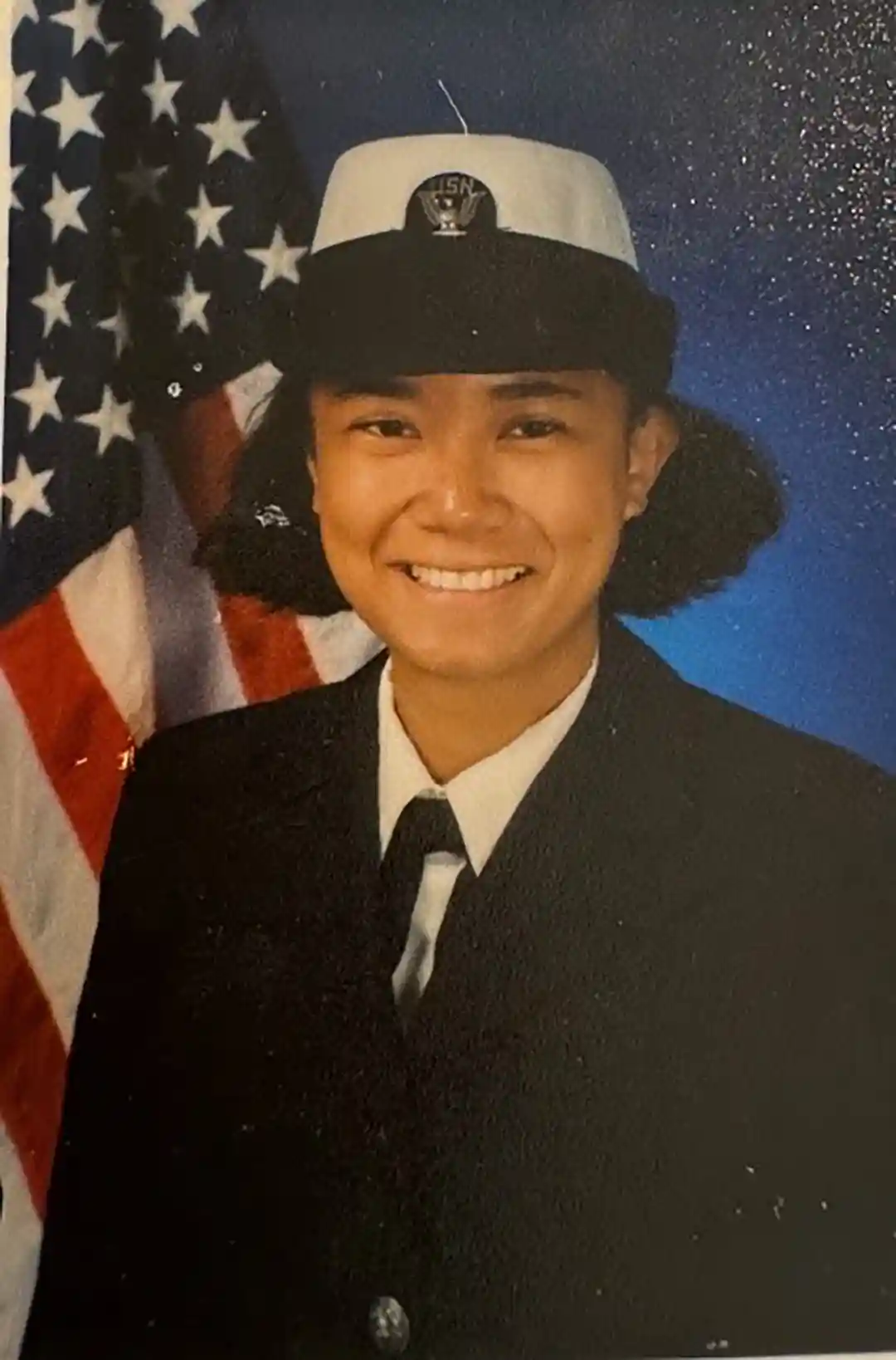 U.S. Navy Veteran Holland America Line View of person in military uniform with American flag in background.