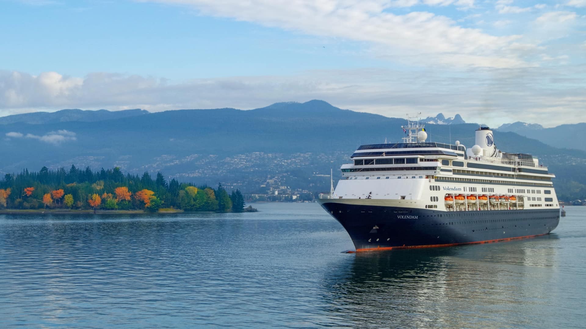 061025_SEO Blog_The Best Time to Cruise to AK_Ship in Fall Holland America cruise ship next to colorful fall foliage and mountains.