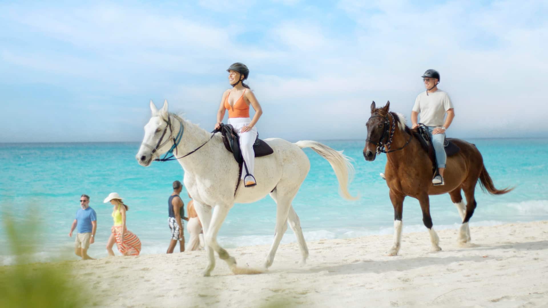 Couple riding horses on the beach on a cruise excursion.