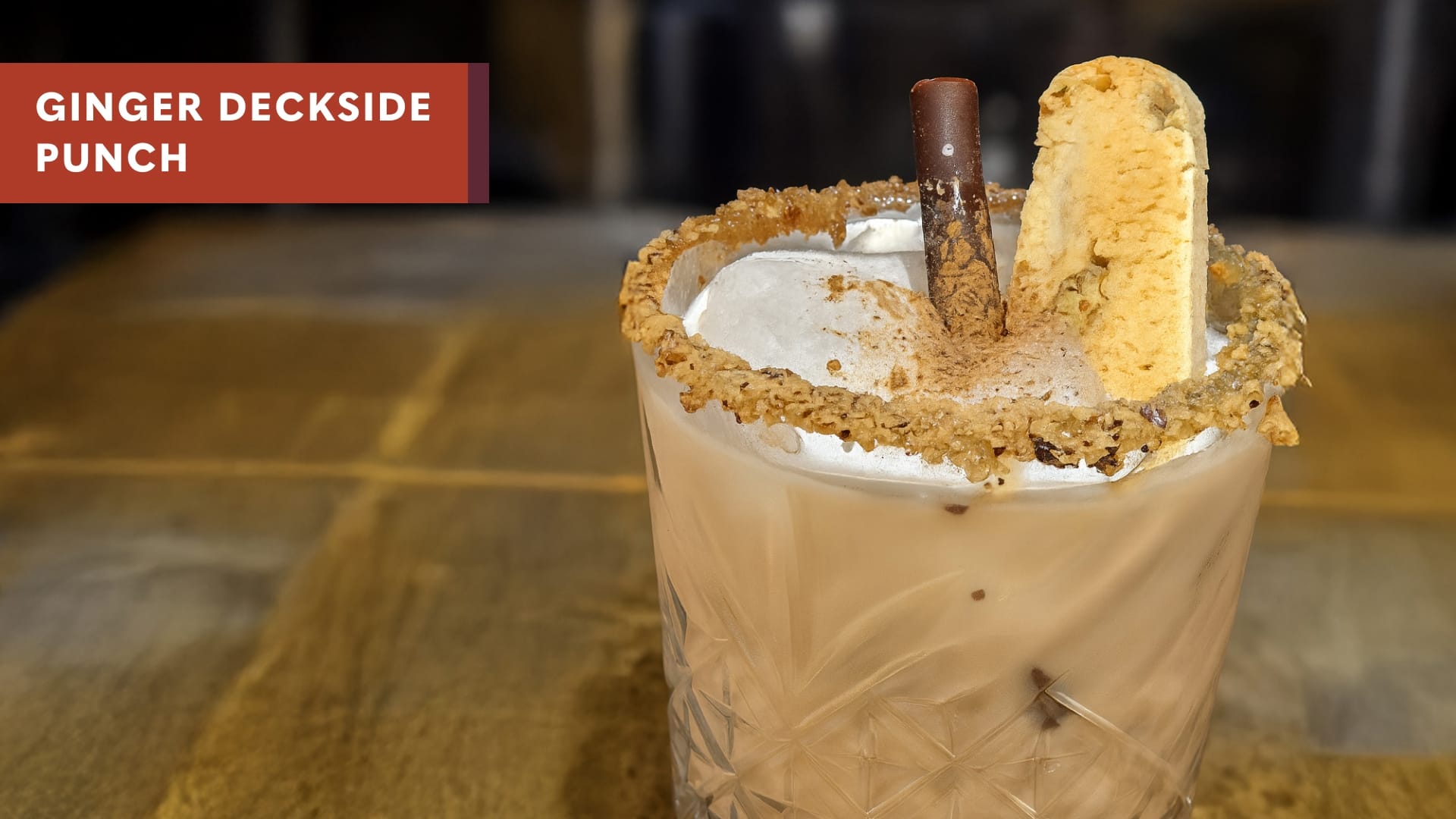 Ginger Deckside Punch, a holiday cocktail garnished with biscotti & a cinnamon roll stick.