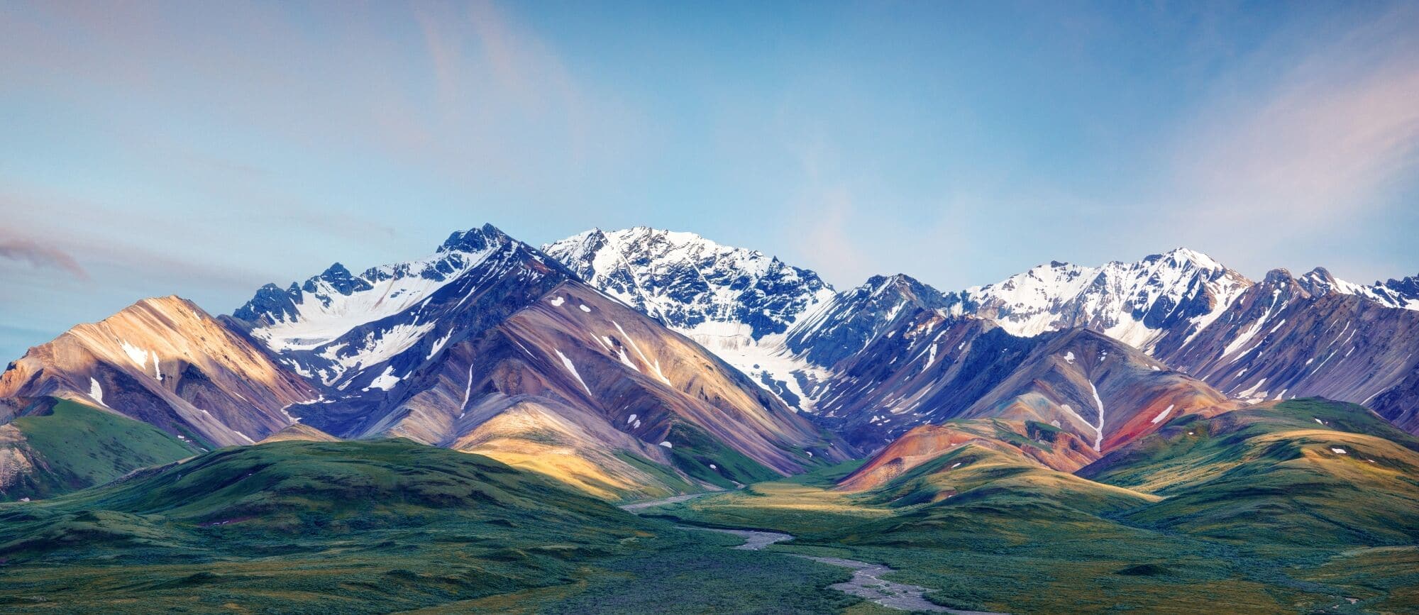 Mountain range with colorful slopes and a winding river in the valley.
