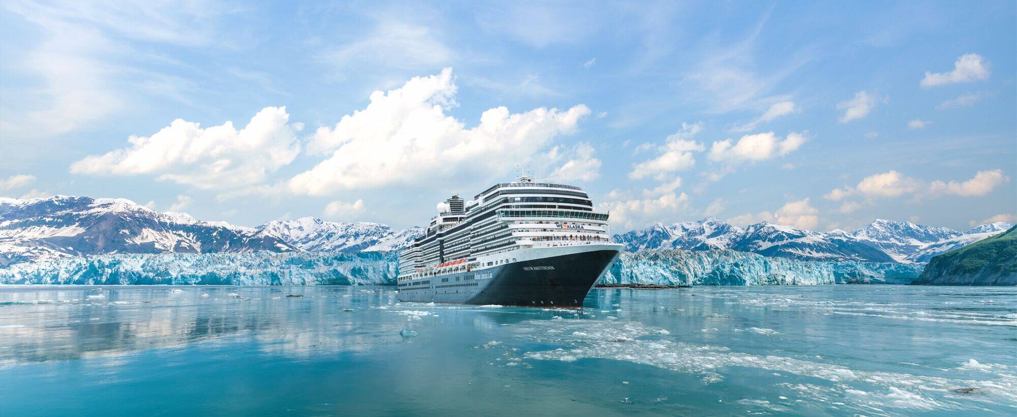 Cruise ship sailing through Glacier Bay with snow-covered mountains and glaciers.