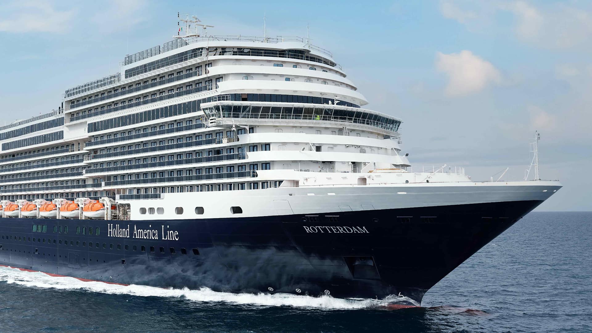 Rotterdam, Holland America’s newest cruise ship, moving through the water beneath the blue sky.