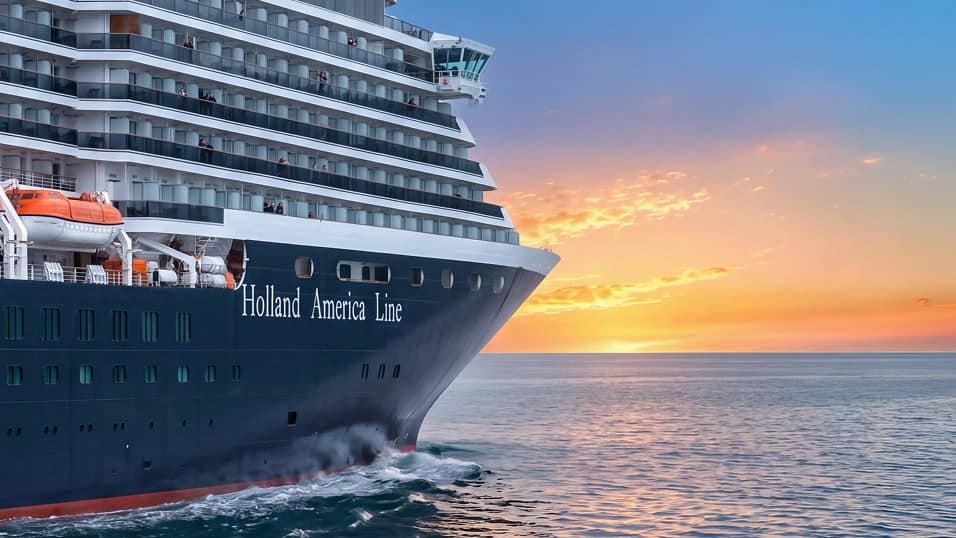 welcome-arcadia-evolution-header-blog Holland America ship on the ocean in front of a sunset