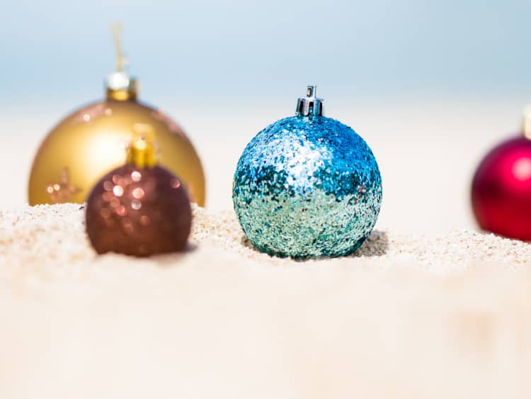 Glittery ornaments nestled in the sand on a Holland America Line Holiday Cruise