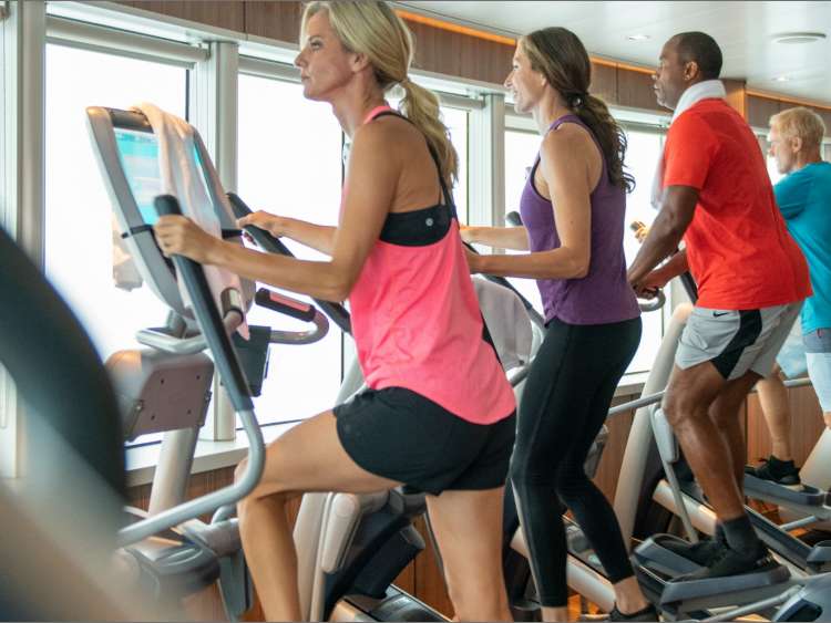 Four people working out in a fitness center onboard a ship