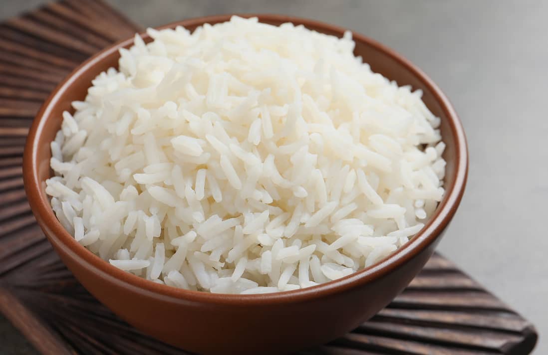 Wooden bowl filled with fluffy steamed rice.