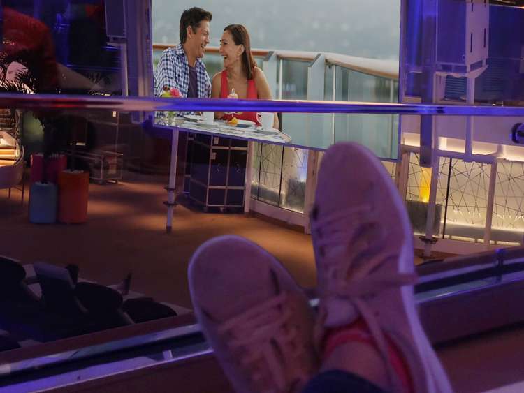 person watching movie on deck at night