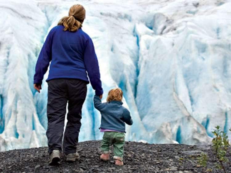A woman and child explore near an Alaskan glacier on a Holland America Line Alaska shore excursion