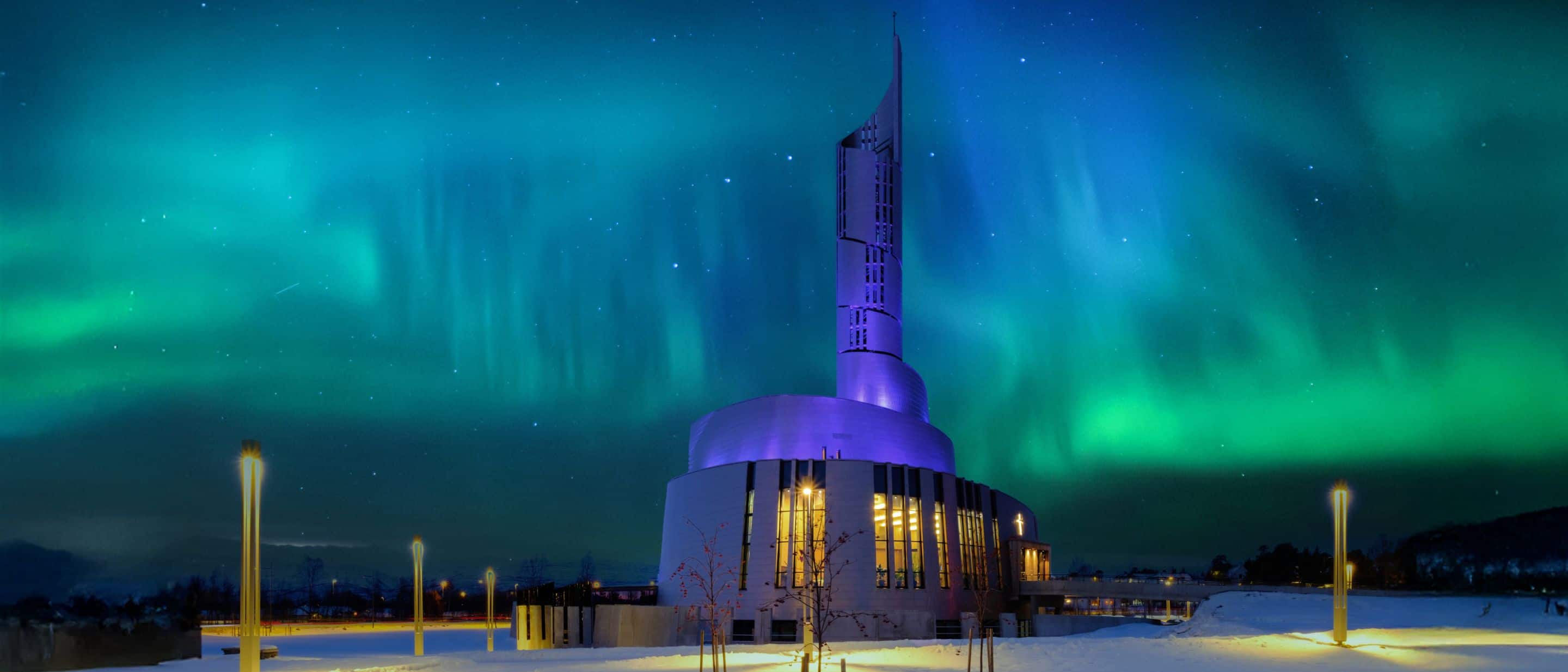 Northern Lights Cathedral at night with aurora borealis overhead.