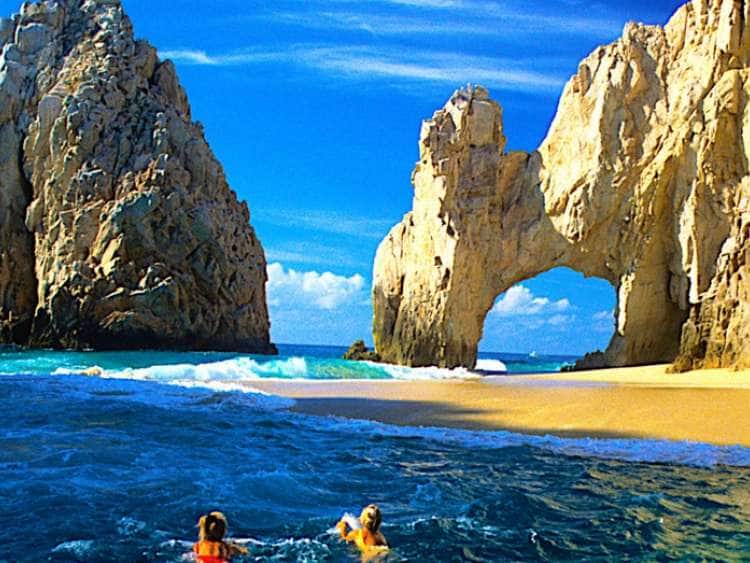 View of two people swimming on a beach in Cabo San Lucas while on a Mexico cruise