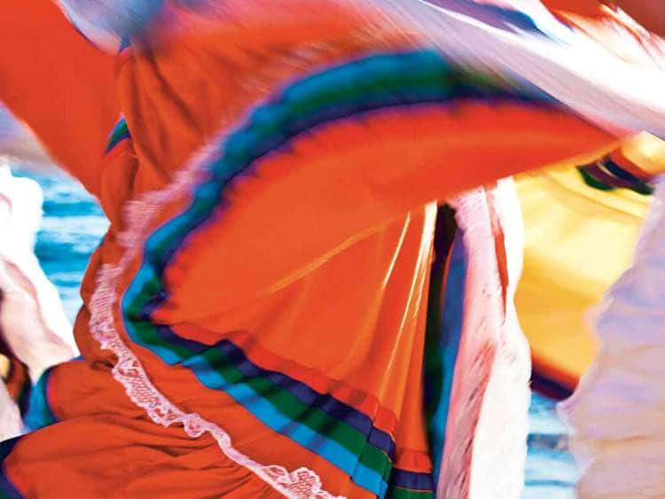 Mexican dancers in long dresses spinning at celebration