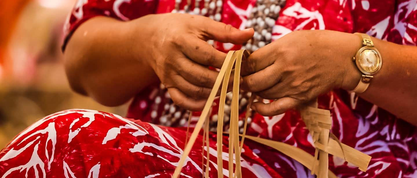 A Polynesian woman weaving natural plant fibers