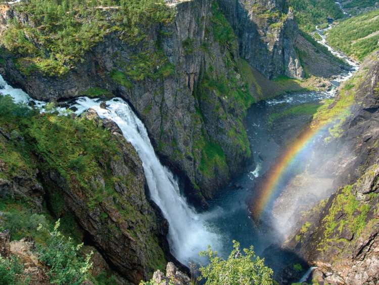 Large waterfall and rainbow landscape in Norway mountains