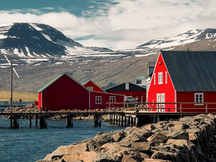 A view of a red barn from the water of Port Eskifjordur Iceland